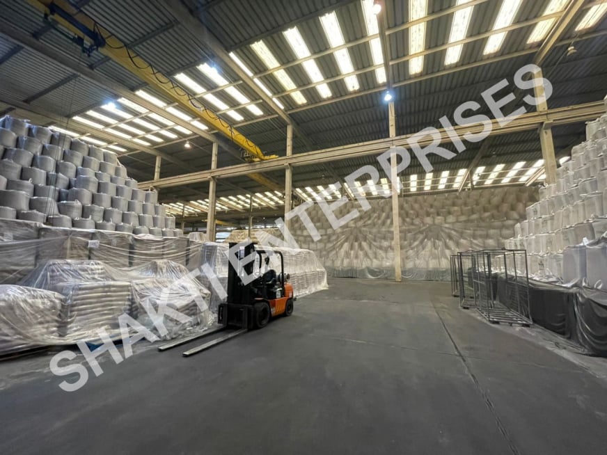 Pallets of bulk white sugar bags in a warehouse, ready for export, emphasizing the large quantities available.